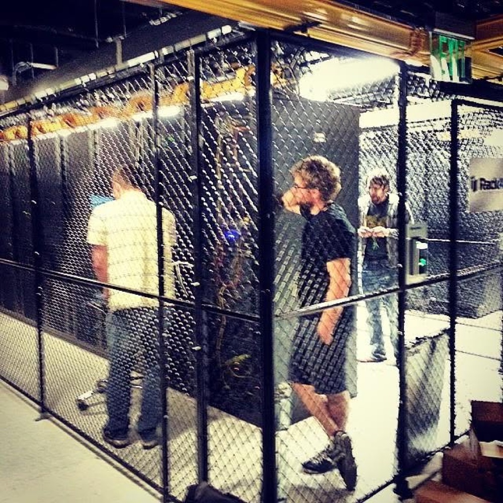Data center access cage with technicians reviewing infrastructure