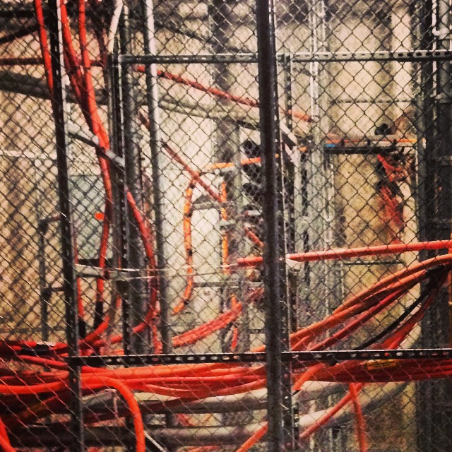 Orange fiber optic innerduct runs behind a data center cage